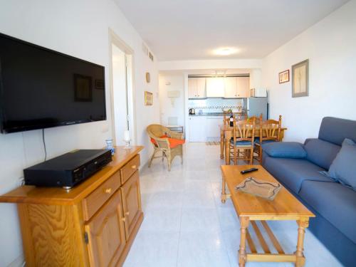 un soggiorno con divano blu e tavolo di Apartment Turquesa Beach-5 by Interhome a Calpe