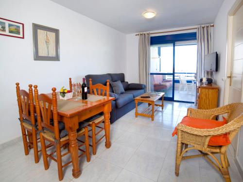 salon ze stołem, krzesłami i kanapą w obiekcie Apartment Turquesa Beach-5 by Interhome w mieście Calpe