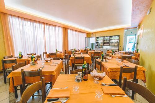 a restaurant with wooden tables and chairs with bottles on them at Hotel Edera in Sottomarina