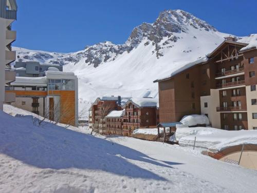 une montagne enneigée derrière une ville avec des bâtiments dans l'établissement Apartment Le Pramecou - Val Claret-15 by Interhome, à Tignes
