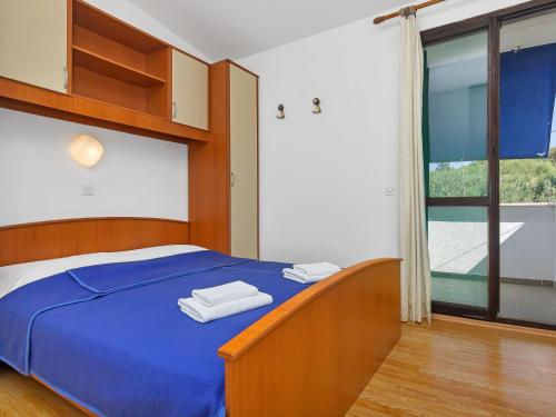 een slaapkamer met een blauw bed met handdoeken erop bij Apartment Cico-6 by Interhome in Selca kod Bogomolja