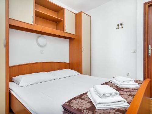 a small bedroom with a bed and a chair at Apartment Cico-8 by Interhome in Selca kod Bogomolja