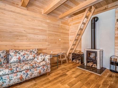 een woonkamer met een bank en een houtkachel bij Chalet Plitvice II by Interhome in Rudanovac