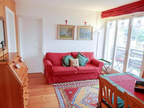 a living room with a red couch with pillows on it at Apartment Europa 2-1 by Interhome in Vermala