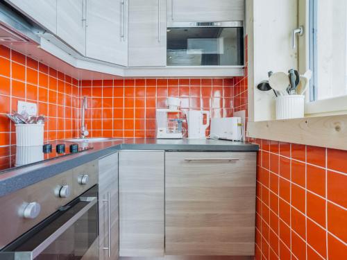 a kitchen with an orange tiled wall at Apartment Altitude 2100 by Interhome in Tignes