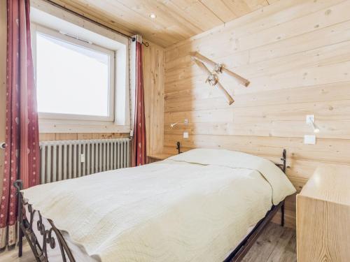 a bed in a wooden room with a window at Apartment Altitude 2100 by Interhome in Tignes