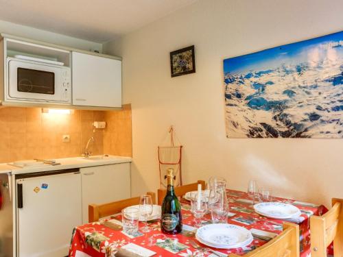 a kitchen with a table with a bottle of wine at Apartment Les Olympiques-10 by Interhome in Les Boisses