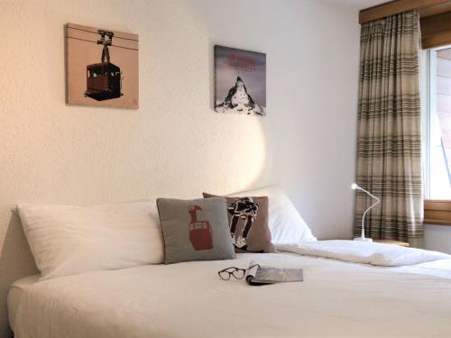 - une chambre avec un lit doté de draps blancs et une fenêtre dans l'établissement Apartment Bellevue-6 by Interhome, à Zermatt