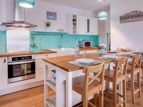 a kitchen with a wooden table and a kitchen with blue at Apartment Cantegrit by Interhome in Capbreton