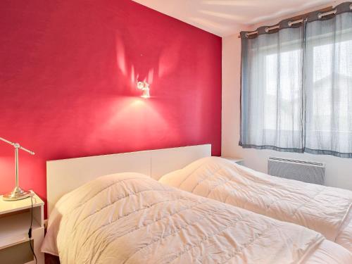 - une chambre avec un mur rouge et un lit dans l'établissement Apartment Cantegrit by Interhome, à Capbreton