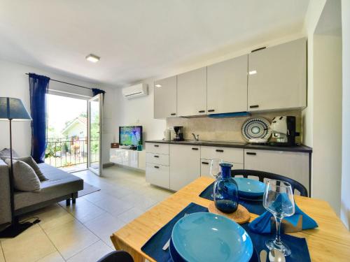 Il comprend une cuisine et un salon doté d'une table en bois avec des plaques bleues. dans l'établissement Apartment Beni-2 by Interhome, à Matulji