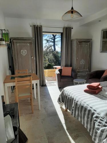 1 dormitorio con cama, mesa y sofá en LE LAVANDIN, en Flayosc