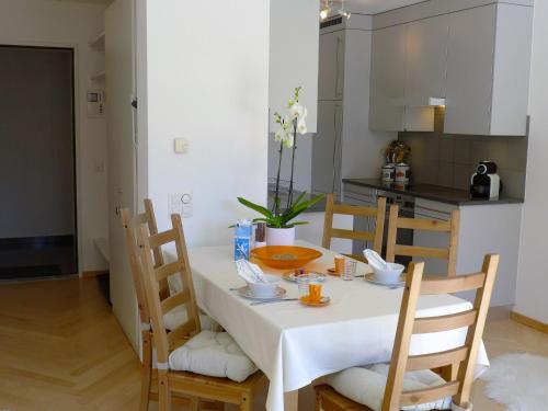 サンモリッツにあるApartment Chesa Sur Ova 21 by Interhomeのキッチン(白いテーブル、椅子、白いテーブル、チェアトップ付)