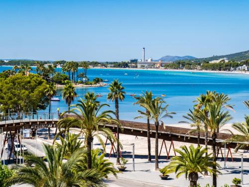 a view of a beach with palm trees and a pier at Apartment Mariners 4 by Interhome in Alcudia