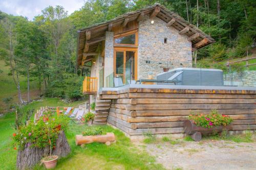 a small log cabin with a large window on it at Baita Relais La Cesarina in Vico Canavese