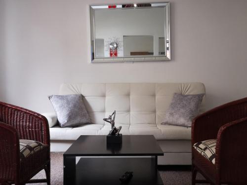 a living room with a white couch and a mirror at Cómodos y acogedores Apartaestudios - Manizales in Manizales
