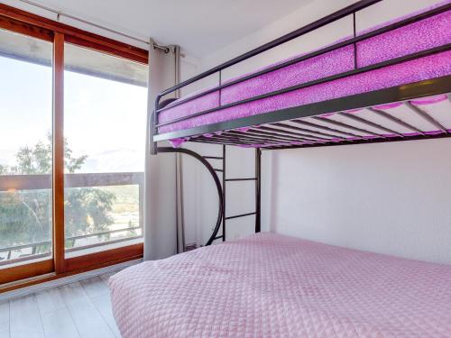 a bedroom with a bunk bed and a large window at Apartment Soyouz Vanguard-82 by Interhome in Le Corbier