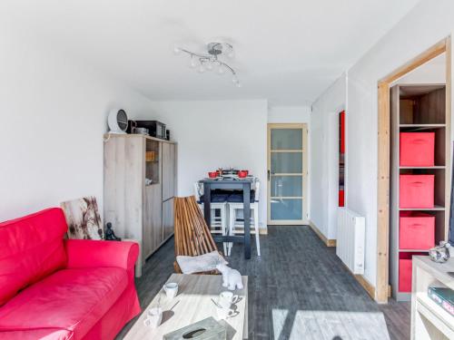 a living room with a red couch and a table at Apartment Pegase Phenix-67 by Interhome in Le Corbier
