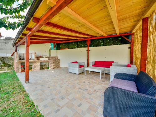 a patio with a wooden pergola and two couches at Holiday Home Lana 1 by Interhome in Matulji