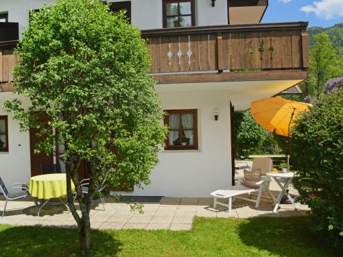 a house with a balcony and an orange umbrella at Apartment Wohnung 4 - Am Sonneneck by Interhome in Ruhpolding