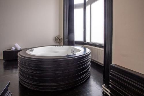 a large round bath tub in a room with a window at B&B Suites FEEK in Antwerp