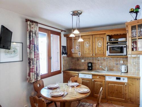 a kitchen with a wooden table with chairs and a window at Apartment Le Plan des Reines by Interhome in Chamonix-Mont-Blanc