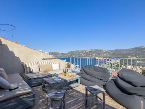 d'une terrasse avec des canapés et des chaises sur un balcon. dans l'établissement Apartment La Porte Génoise by Interhome, à Porto-Vecchio