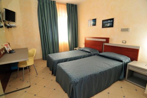 Pokój hotelowy z 2 łóżkami i biurkiem w obiekcie La Locanda del Cavaliere w mieście Borgo Montello