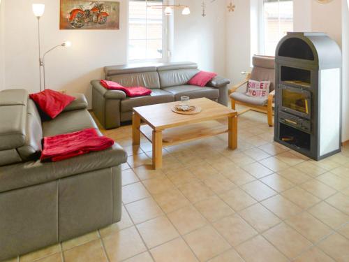ein Wohnzimmer mit Sofas und einem Holzofen in der Unterkunft Holiday Home Reuse by Interhome in Norddeich