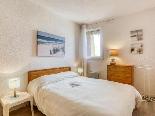 une chambre avec un grand lit blanc et une fenêtre dans l'établissement Apartment Trinquart-6 by Interhome, à Seignosse