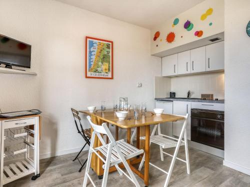 uma cozinha com mesa e cadeiras num quarto em Apartment Trinquart-6 by Interhome em Seignosse
