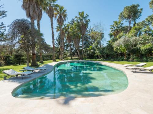 einen Pool mit Palmen im Hof in der Unterkunft Villa Giulia by Interhome in La Massimina-Casal Lumbroso