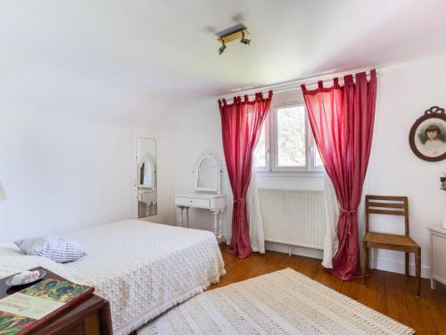una camera con letto e finestra con tende rosse di Holiday Home Da Tim'bi by Interhome a Cabourg