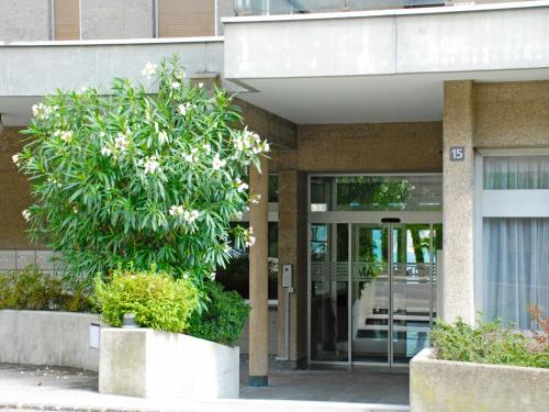 a building with a tree in front of a building at Apartment Apt- Lugano Majestic Panorama by Interhome in Lugano
