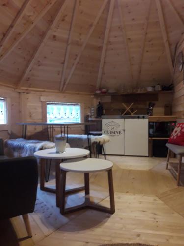 ein Wohnzimmer mit 2 Tischen und einem Sofa in der Unterkunft Le Kota Montagne in Les Poulières