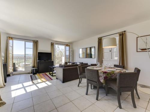 a living room with a dining table and a couch at Apartment Les Terrasses de Grimaud by Interhome in Grimaud