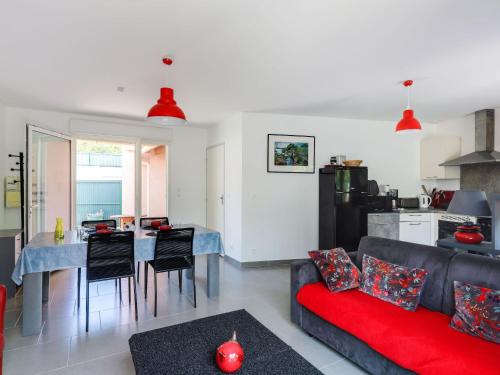 un salon avec un canapé rouge et une cuisine dans l'établissement Holiday Home Villa Robinson by Interhome, à Saint-Raphaël