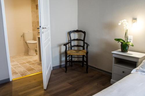 - une chambre avec une chaise à côté d'une salle de bains dans l'établissement HOTEL DE FRANCE - Hôtel de charme en Provence, à Saint-Maximin-la-Sainte-Baume