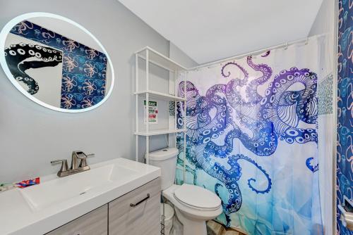 a bathroom with a toilet and a shower curtain with an octopus at MERMAID HOUSE WITH POOL JACUZZI STEPS to SIESTA KEY BEACH in Sarasota