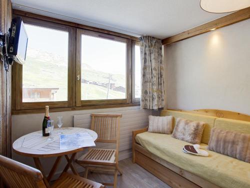 Cette petite chambre dispose d'un canapé, d'une table et d'une fenêtre. dans l'établissement Studio Palafour - Le Lac-3 by Interhome, à Tignes