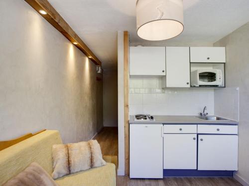 a small kitchen with white cabinets and a couch at Studio Palafour - Le Lac-3 by Interhome in Tignes