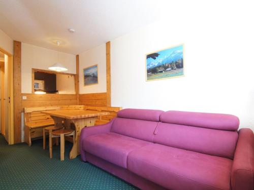 Una sala de estar con un sofá morado y una mesa. en Apartment Jonquilles-10 by Interhome, en Chamonix-Mont-Blanc