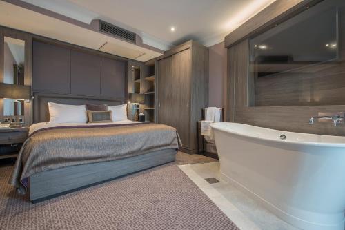 a bedroom with a bed and a bath tub at Crowne Plaza - Sheffield by IHG in Sheffield