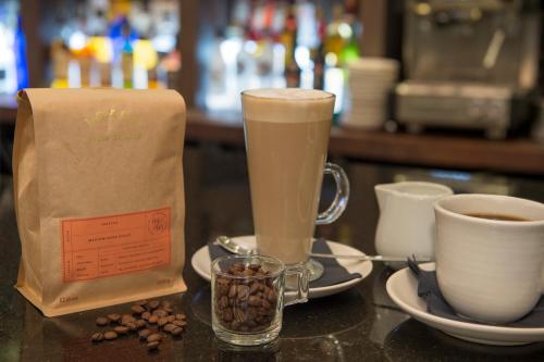 a cup of coffee and a bag of coffee beans and a cup of coffeeastery at Crowne Plaza - Sheffield by IHG in Sheffield