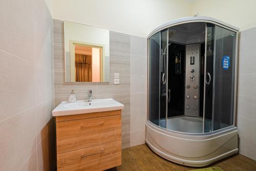 een badkamer met een douche en een wastafel bij Jako Boutique Hotel in Tbilisi City