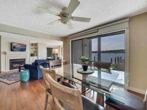 a dining room with a glass table and a ceiling fan at 101 Edgewater Inn in Charlevoix