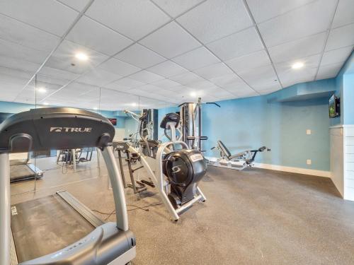 a gym with several tread machines in a room at 101 Edgewater Inn in Charlevoix
