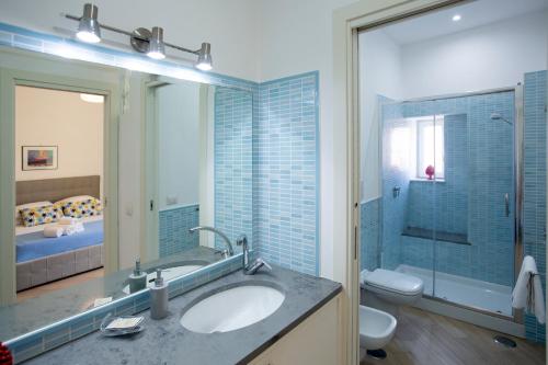 een badkamer met een wastafel, een toilet en een spiegel bij Casa Miniero Sorrento Center in Sorrento