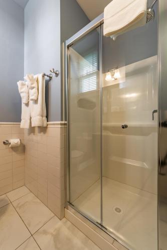 a shower with a glass door in a bathroom at Homestead Inn in New Milford