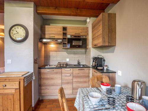 a kitchen with a table and a clock on the wall at Studio Les Grets-10 by Interhome in Saint-Gervais-les-Bains